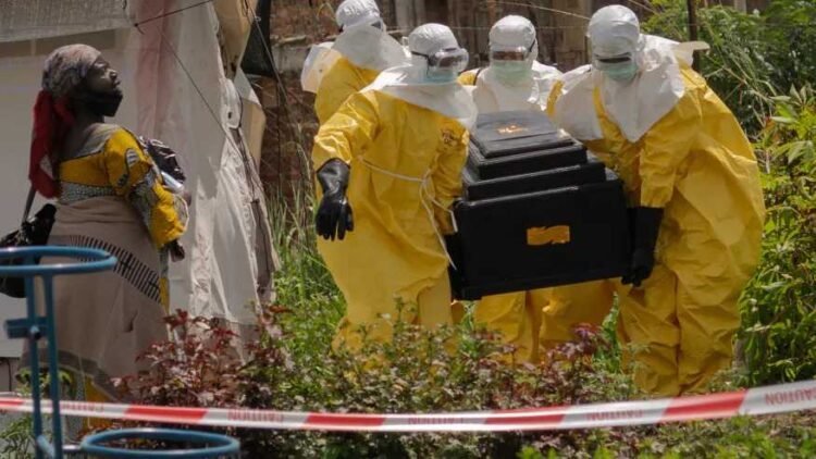 A-woman-cries-as-Red-Cross-workers-carry-the-coffin-of-a-person-who-died-of-Ebola-from-a-health-center-in-Rwampara-Congo-Wednesday-May-20-2026.