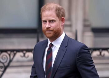 Prince Harry, Duke of Sussex, in a navy suit and striped tie, standing outside a formal London building — pictured in connection with his public warning about the rise of antisemitism in the United Kingdom.